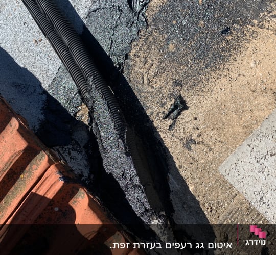 צינור שחור על גג עם חומר איטום שחור
